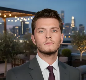 "الممثل بوراك توزكوباران في دور علي من مسلسل تحت نفس المطر، يظهر بتعبيرات وجه حازمة بملابس رسمية."